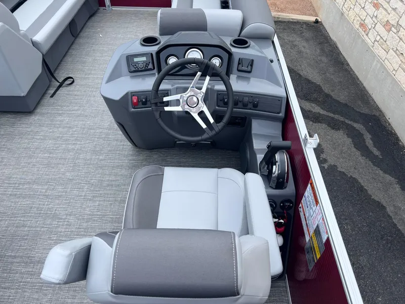Slide: The Image of 2024 Bennington 22SV boat helm with modern steering and controls, featuring gray seating. - 7