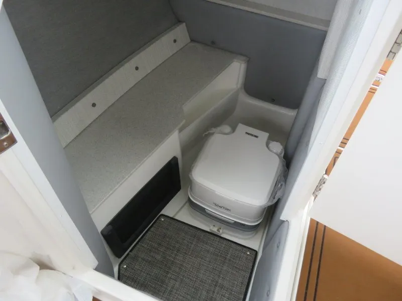 Slide: The Image of 2023 Cobalt R6 Surf boat interior with compact toilet and seating area. - 4