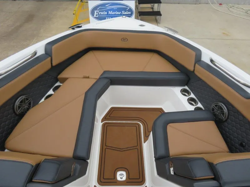 Slide: The Image of 2023 Cobalt R6 Surf boat interior with tan and black seating, cup holders, and speakers. - 5