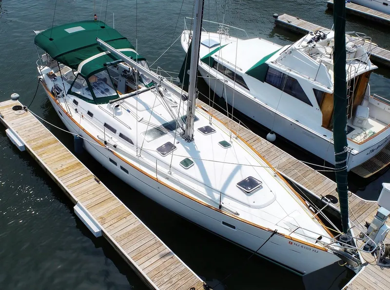 Slide: The Image of 2005 Beneteau 423 sailboat docked at marina, featuring green canopy and sleek design. - 1