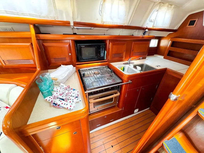 Slide: The Image of Interior of 2005 Beneteau 423 yacht kitchen with wood cabinetry and modern appliances. - 14