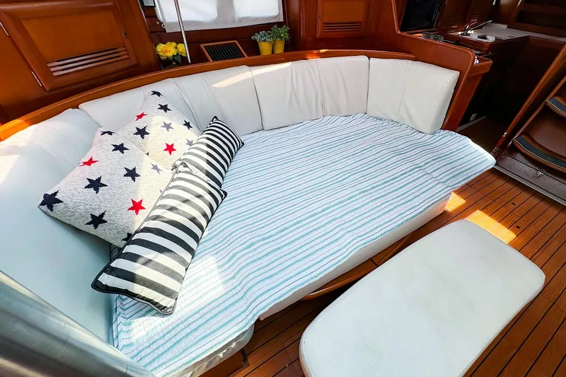 Slide: The Image of Beneteau 423 yacht interior with cozy seating, striped and star-patterned cushions, 2005 model. - 18