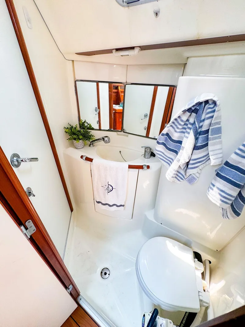 Slide: The Image of Beneteau 423 2005 yacht bathroom with sink, mirror, and striped towels. - 23
