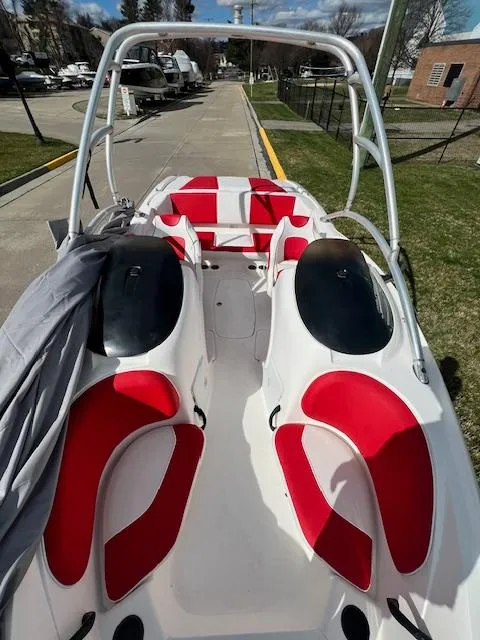 Slide: The Image of 2004 Yamaha Boats AR 210 with red and white seating, docked on a sunny day. - 13