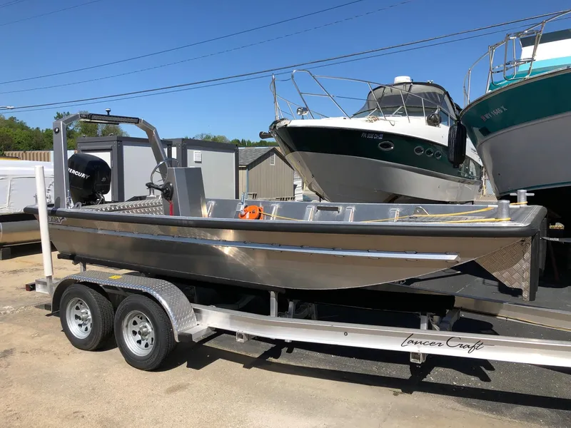 The Image of 2023 HasCraft 500 All Around boat on trailer, parked near other boats. - 1