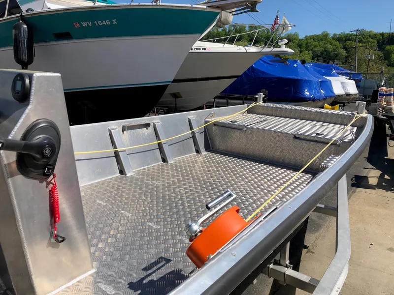 Slide: The Image of 2023 HasCraft 500 All Around aluminum boat docked near other boats. - 5