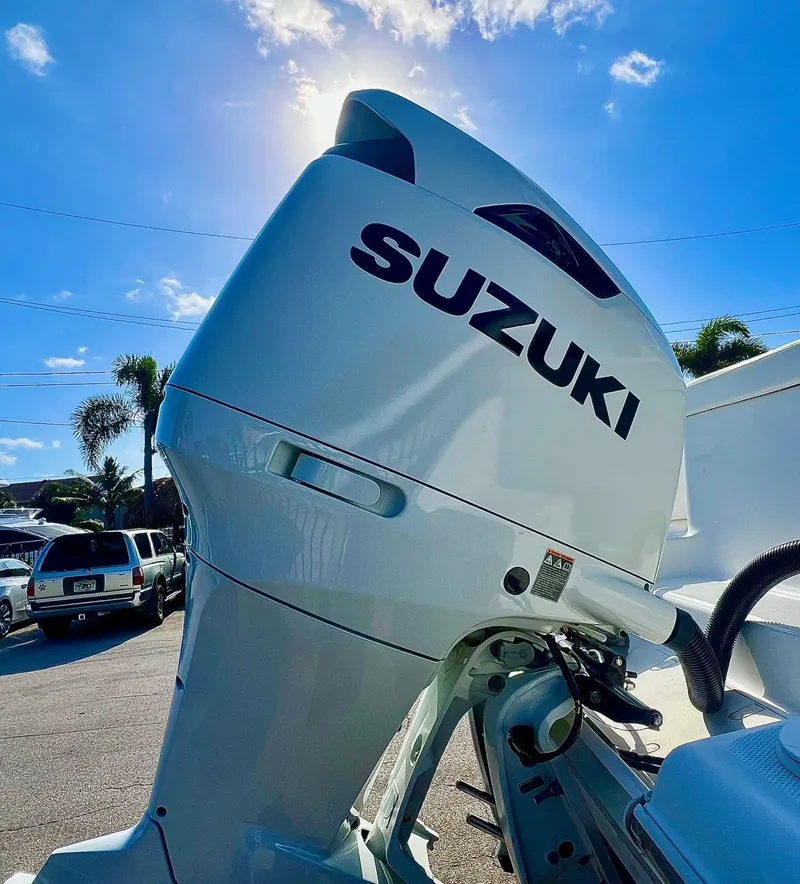 Slide: The Image of 2024 NauticStar 193SC Sport Deck with Suzuki outboard motor under sunny sky. - 17
