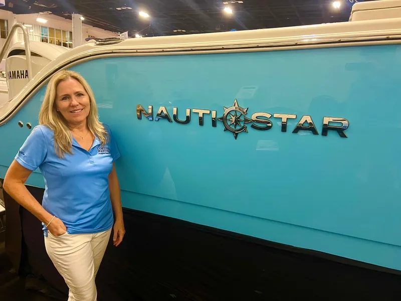 Slide: The Image of Woman standing beside 2024 NauticStar 193SC Sport Deck boat at an indoor event. - 23