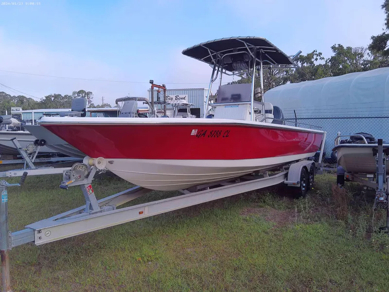 Slide: The Image of 2008 Clearwater 2400 Baystar Bay Boat on trailer, red hull, parked on grass. - 2