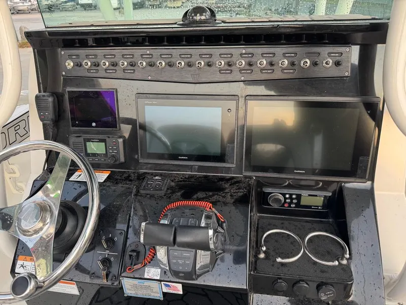 Slide: The Image of 2019 Wellcraft 262 Fisherman dashboard with multiple screens and controls. - 14