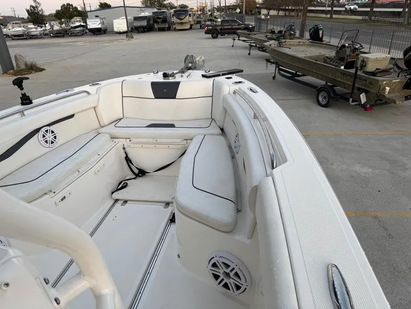 Slide: The Image of 2019 Wellcraft 262 Fisherman boat interior with seating and speakers, parked in a lot. - 17
