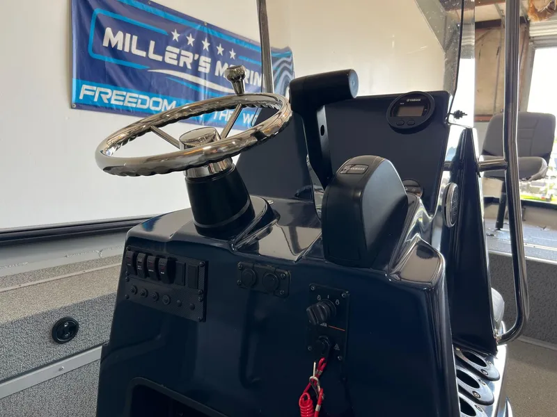 Slide: The Image of 2024 SeaArk 2072 FXT boat console with steering wheel and controls. - 7