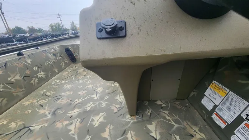 Slide: The Image of 2025 Tracker GRIZZLY® 1754 SC boat interior with camouflage design and control panel. - 11