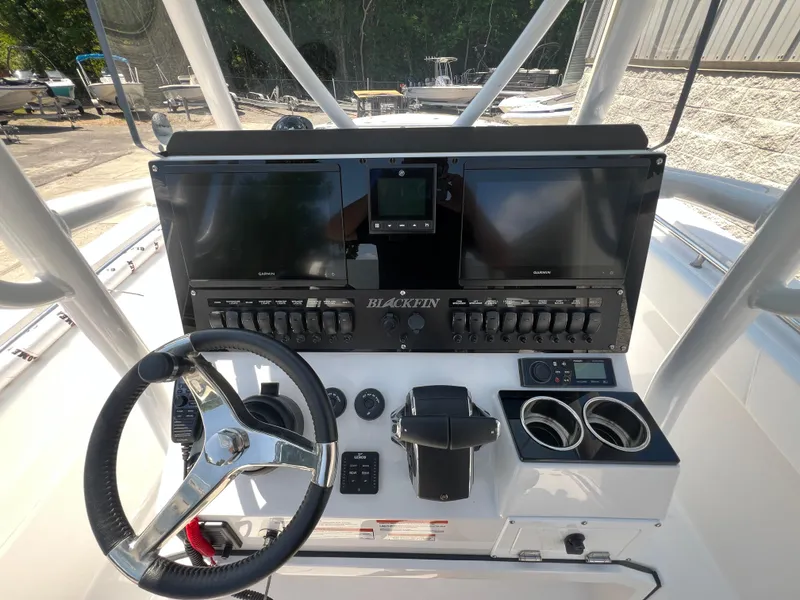 Slide: The Image of 2024 Blackfin 252 CC boat dashboard with steering wheel, dual screens, and control panel. - 16