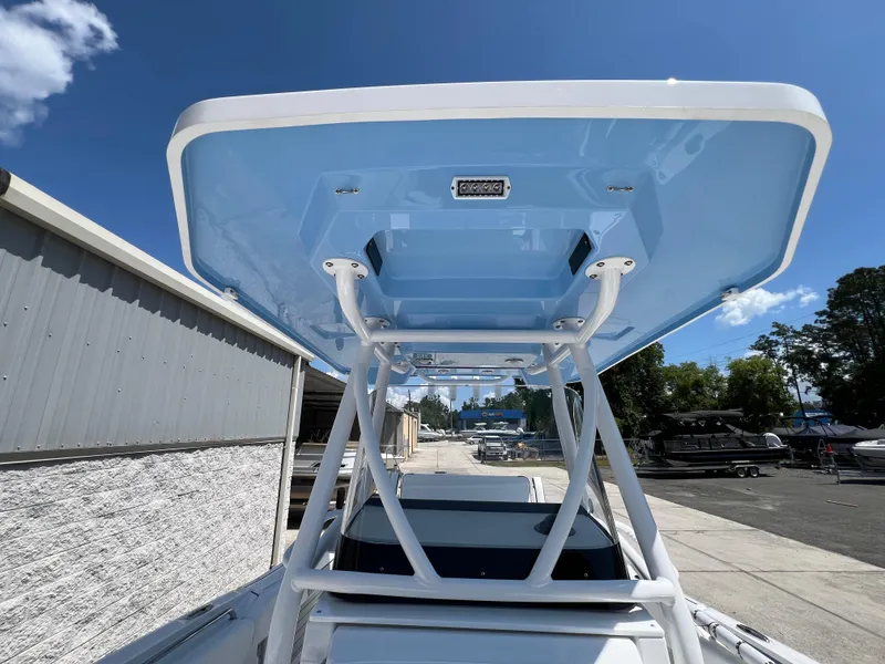 Slide: The Image of 2024 Blackfin 252 CC boat with blue T-top in a marina. - 18