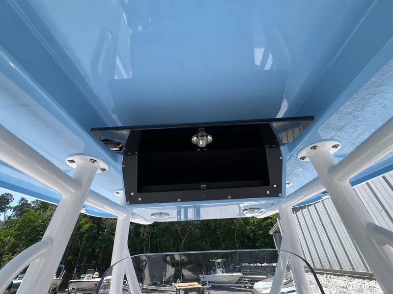 Slide: The Image of 2024 Blackfin 252 CC boat with blue T-top and storage compartment. - 19