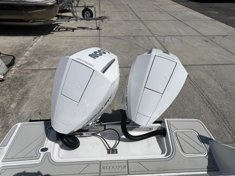 Slide: The Image of 2024 Blackfin 252 CC boat with dual outboard engines on a concrete dock. - 25