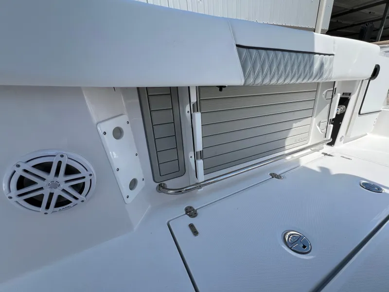 Slide: The Image of 2024 Blackfin 252 CC boat interior with storage compartment and speaker. - 26