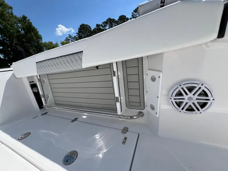 Slide: The Image of 2024 Blackfin 252 CC boat interior with storage compartments and speaker. - 27