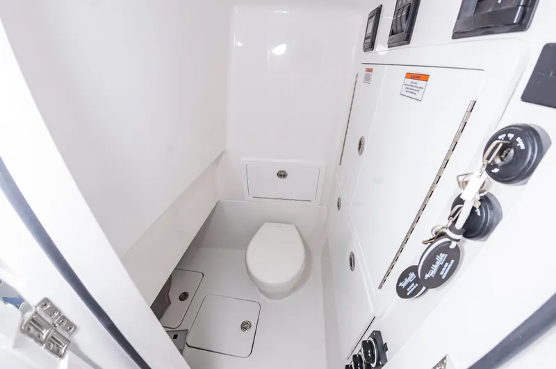 Slide: The Image of 2025 Valhalla Boatworks V-29 interior bathroom with white fixtures and storage compartments. - 33