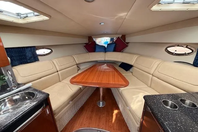 Slide: The Image of Interior of 2008 Formula 350 Sun Sport boat with beige seating and wooden table. - 25