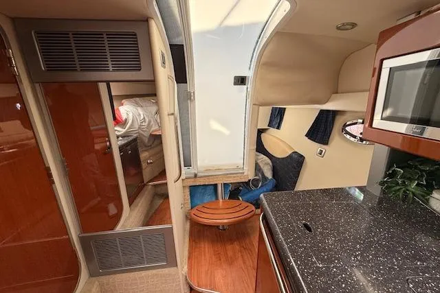 Slide: The Image of Interior of a 2008 Formula 350 Sun Sport boat, featuring a compact kitchen and cozy cabin space. - 29