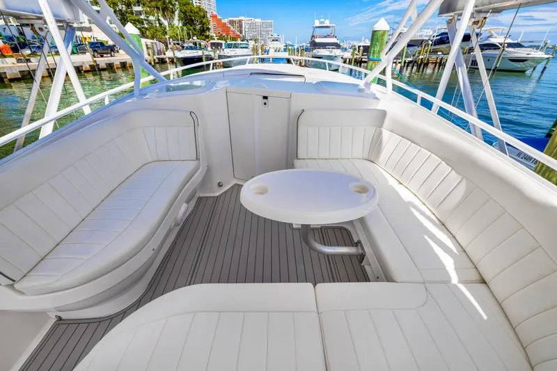 Slide: The Image of 2016 Intrepid 400 Cuddy boat with spacious seating and table at marina. - 12