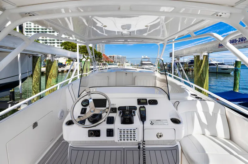 Slide: The Image of 2016 Intrepid 400 Cuddy boat helm with modern controls docked at marina. - 13