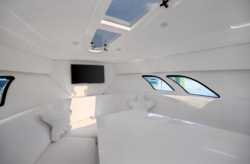 Slide: The Image of 2016 Intrepid 400 Cuddy interior with skylight, TV, and star-shaped pillows. - 20