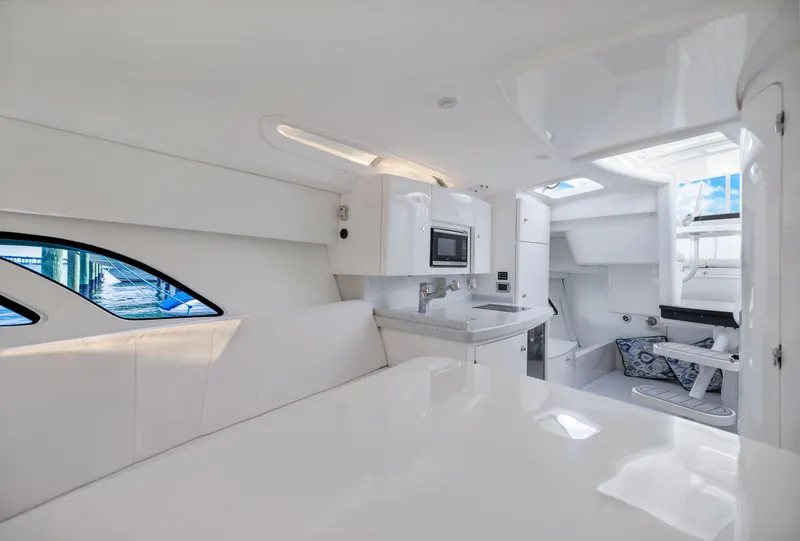 Slide: The Image of Interior of 2016 Intrepid 400 Cuddy, featuring modern white design and compact kitchen area. - 21