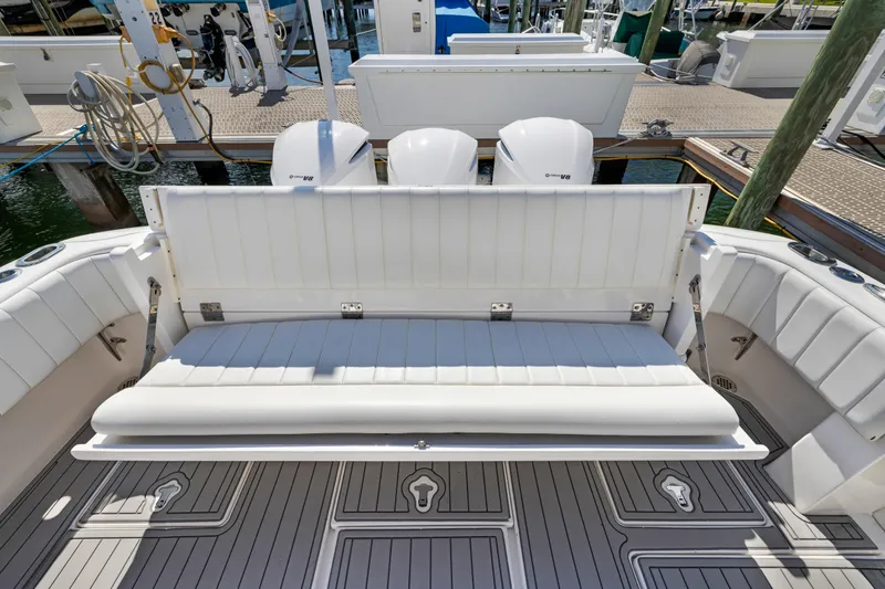 Slide: The Image of 2016 Intrepid 400 Cuddy boat with white seating and triple outboard engines at dock. - 31