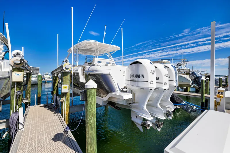 Slide: The Image of 2016 Intrepid 400 Cuddy boat with triple Yamaha engines docked at a marina. - 7