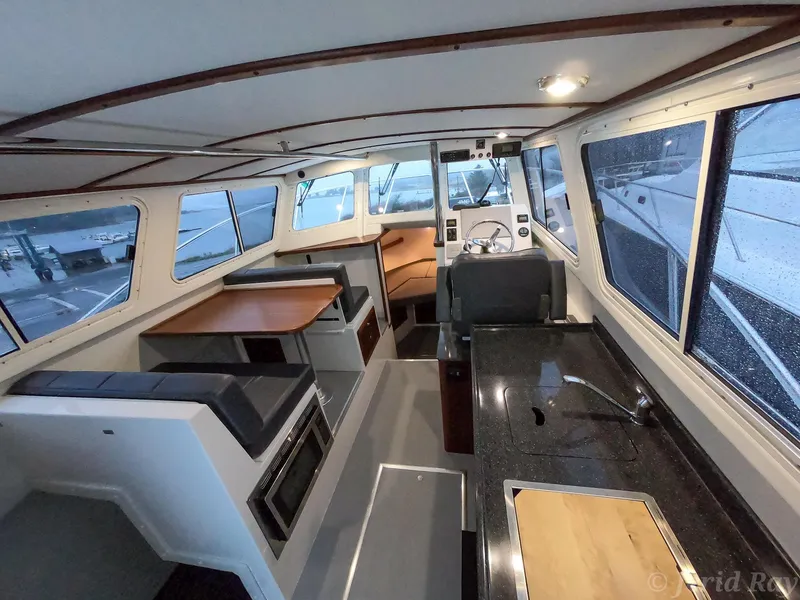 Slide: The Image of Interior of 2025 Ocean Sport Roamer boat with modern seating and navigation area. - 1