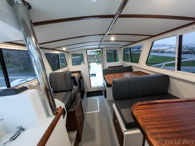 Slide: The Image of Interior of 2025 Ocean Sport Roamer boat with seating and tables. - 3