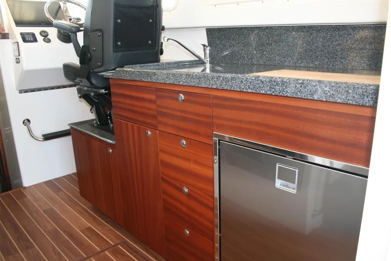 Slide: The Image of 2025 Ocean Sport Roamer interior with modern kitchenette and captain's chair. - 4