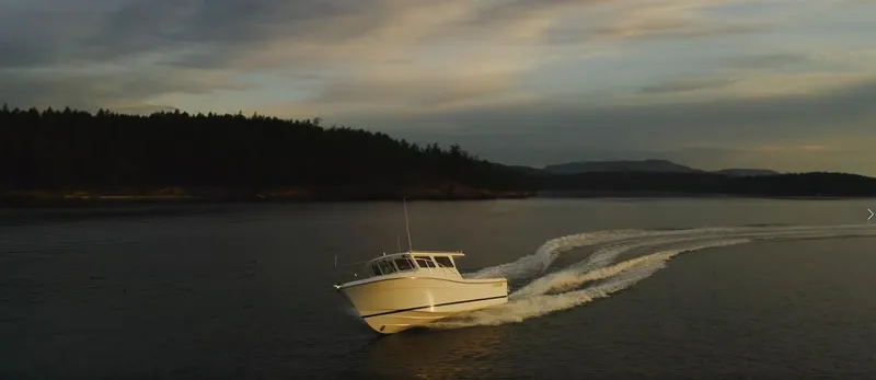 Slide: The Image of 2025 Ocean Sport Roamer cruising on a serene lake at sunset. - 5