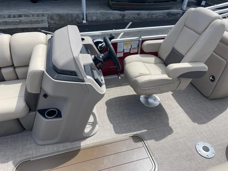 Slide: The Image of 2024 Sun Tracker Party Barge 22 RF XP3 boat interior with captain's chair and console. - 2