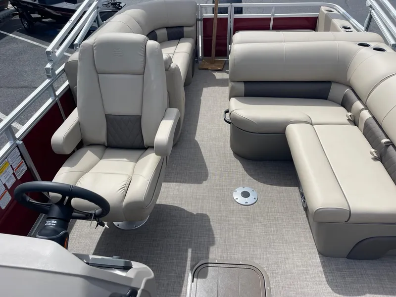 Slide: The Image of 2024 Sun Tracker Party Barge 22 RF XP3 interior with beige seating and steering console. - 6