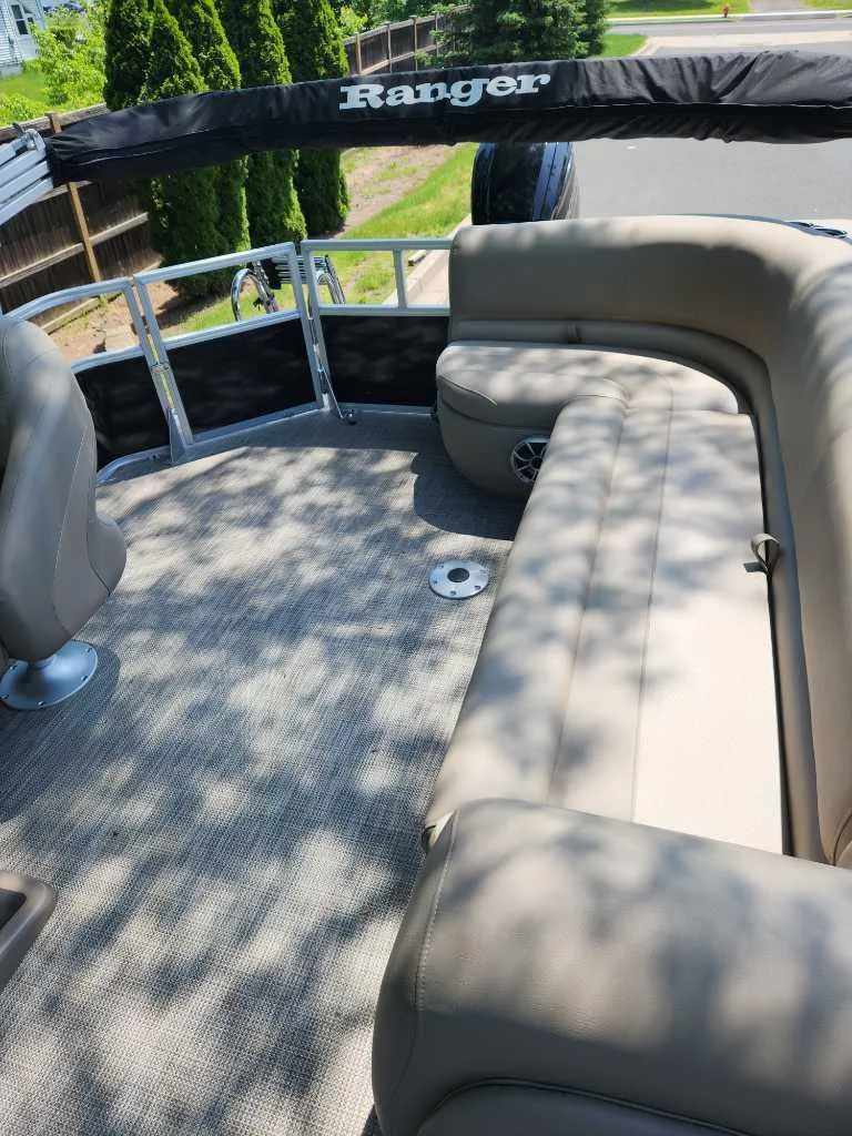 Slide: The Image of 2024 Ranger Reata 200C pontoon boat with beige seating and spacious deck. - 3