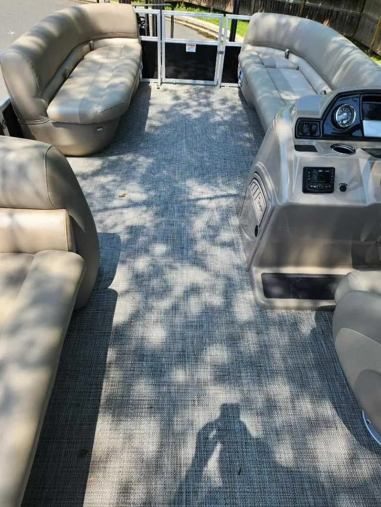 Slide: The Image of 2024 Ranger Reata 200C pontoon boat interior with beige seating and gray flooring. - 7