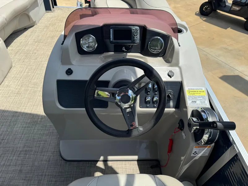 Slide: The Image of 2022 Cypress Cay Seabreeze 232 boat dashboard with steering wheel and control panel. - 7