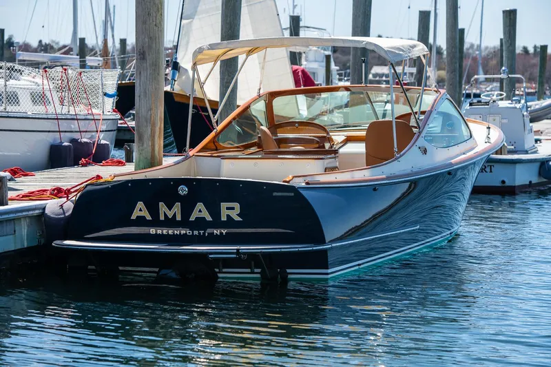 Slide: The Image of 2004 Hinckley Talaria 29 Runabout docked in marina, featuring elegant design and sleek lines. - 1