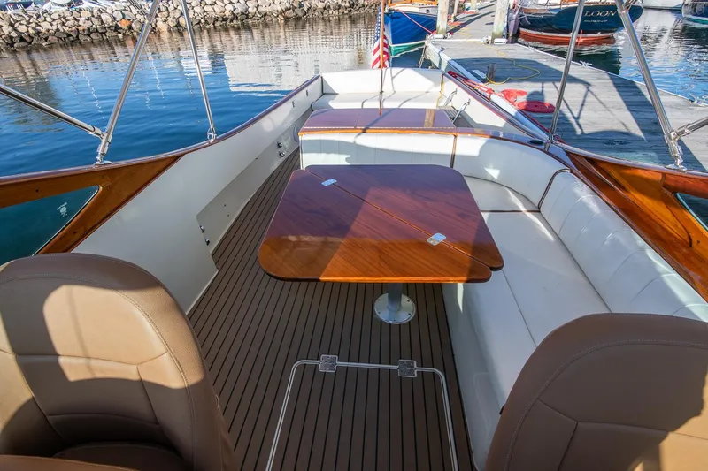 Slide: The Image of 2004 Hinckley Talaria 29 Runabout with elegant seating and wooden table on deck. - 11