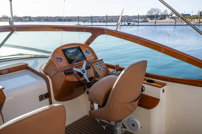 Slide: The Image of 2004 Hinckley Talaria 29 Runabout cockpit with leather seats and wooden dashboard. - 13