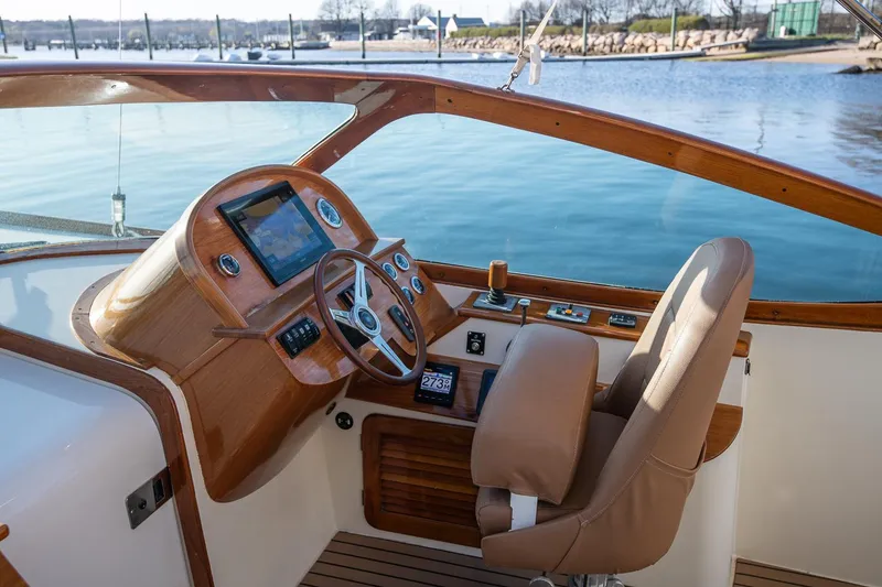 Slide: The Image of 2004 Hinckley Talaria 29 Runabout cockpit with wooden dashboard and leather seat. - 14