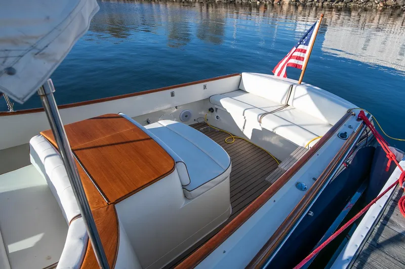 Slide: The Image of 2004 Hinckley Talaria 29 Runabout with American flag, docked on calm water. - 7
