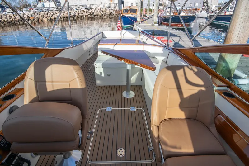 Slide: The Image of 2004 Hinckley Talaria 29 Runabout with elegant seating and wooden deck, docked at marina. - 9