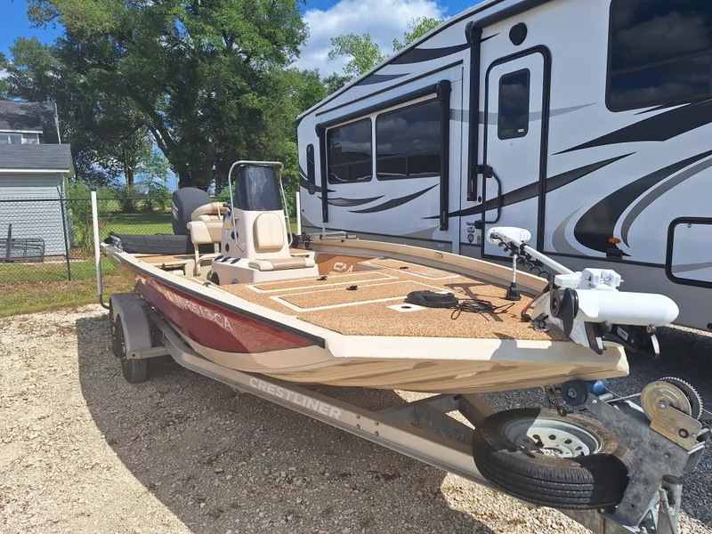 The Image of 2016 Crestliner Bay 2000 boat on trailer, parked beside an RV. - 1