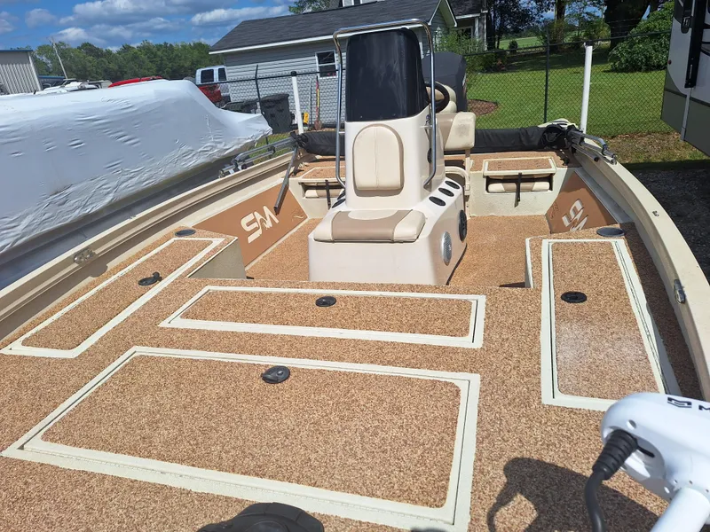 Slide: The Image of 2016 Crestliner Bay 2000 boat with tan deck and seating, parked outdoors. - 5