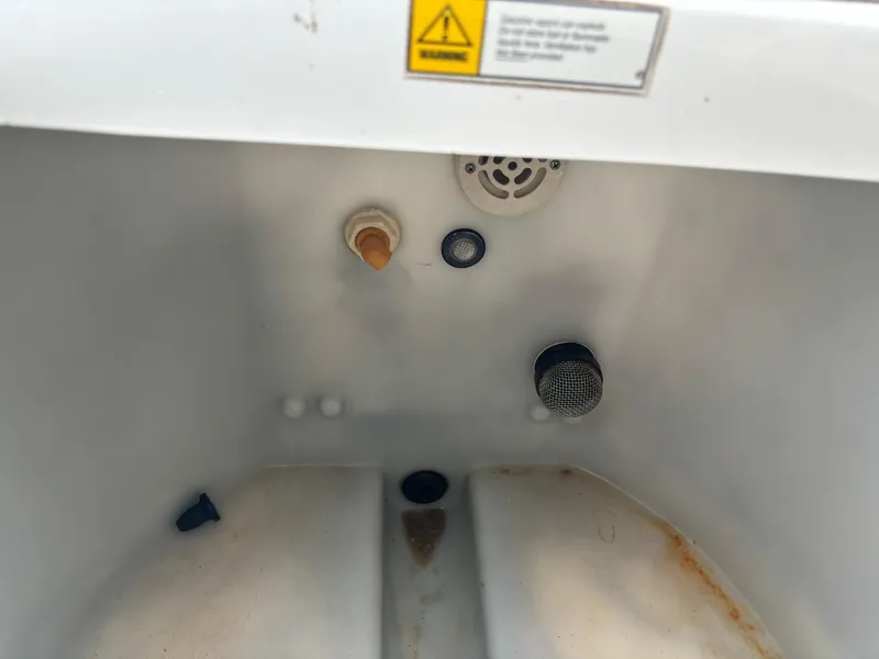 Slide: The Image of Interior of a 1997 Hydra-Sports 21 boat compartment with various fittings and warning label. - 22